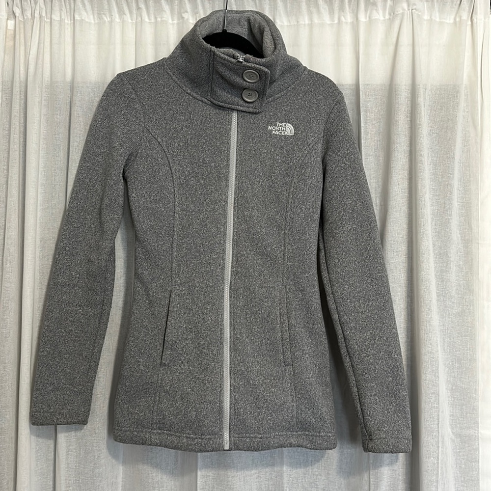 The North Face Zip Up High collar jacket with fleece lining. 2 zip pockets.